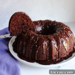Lifting first slice of moist chocolate bundt cake out of cake.