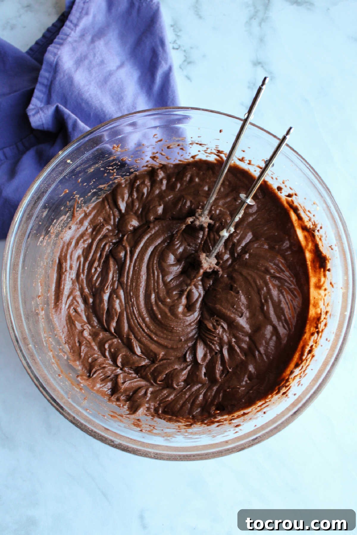 Bowl of chocolate cake batter and mixer beaters.