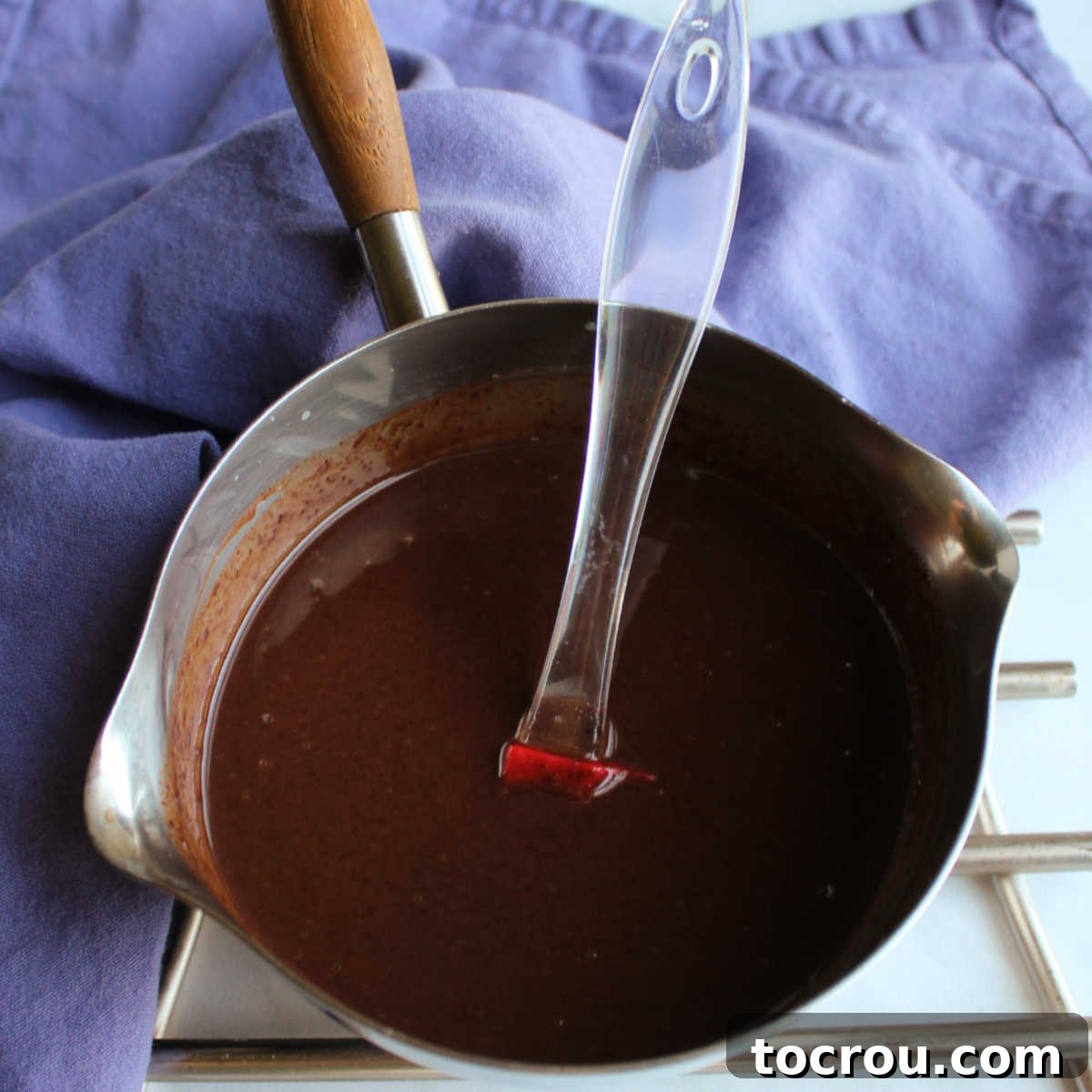 Rich chocolate glaze in saucepan, ready to use.