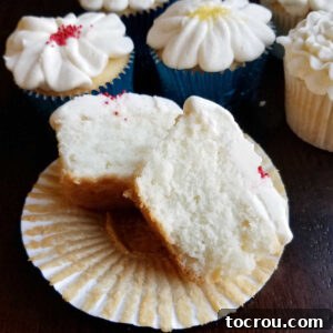 The perfect crumb of a white cupcake, ready to be enjoyed. Semi-homemade white cupcake cut in half, revealing its soft and fluffy interior.