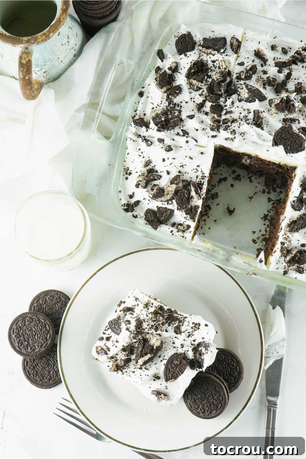 Hole-y Oreo Heaven 9 A 9x13 inch pan containing a delicious Oreo poke cake with one slice neatly removed, showcasing the layers of cake, pudding, and whipped topping, inviting another serving.