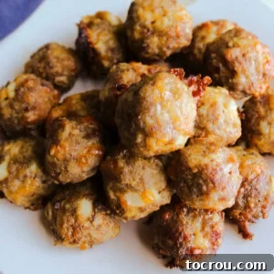 A generous serving of golden-brown breakfast meatballs piled high on a plate, ready to be enjoyed as a hearty and satisfying meal.