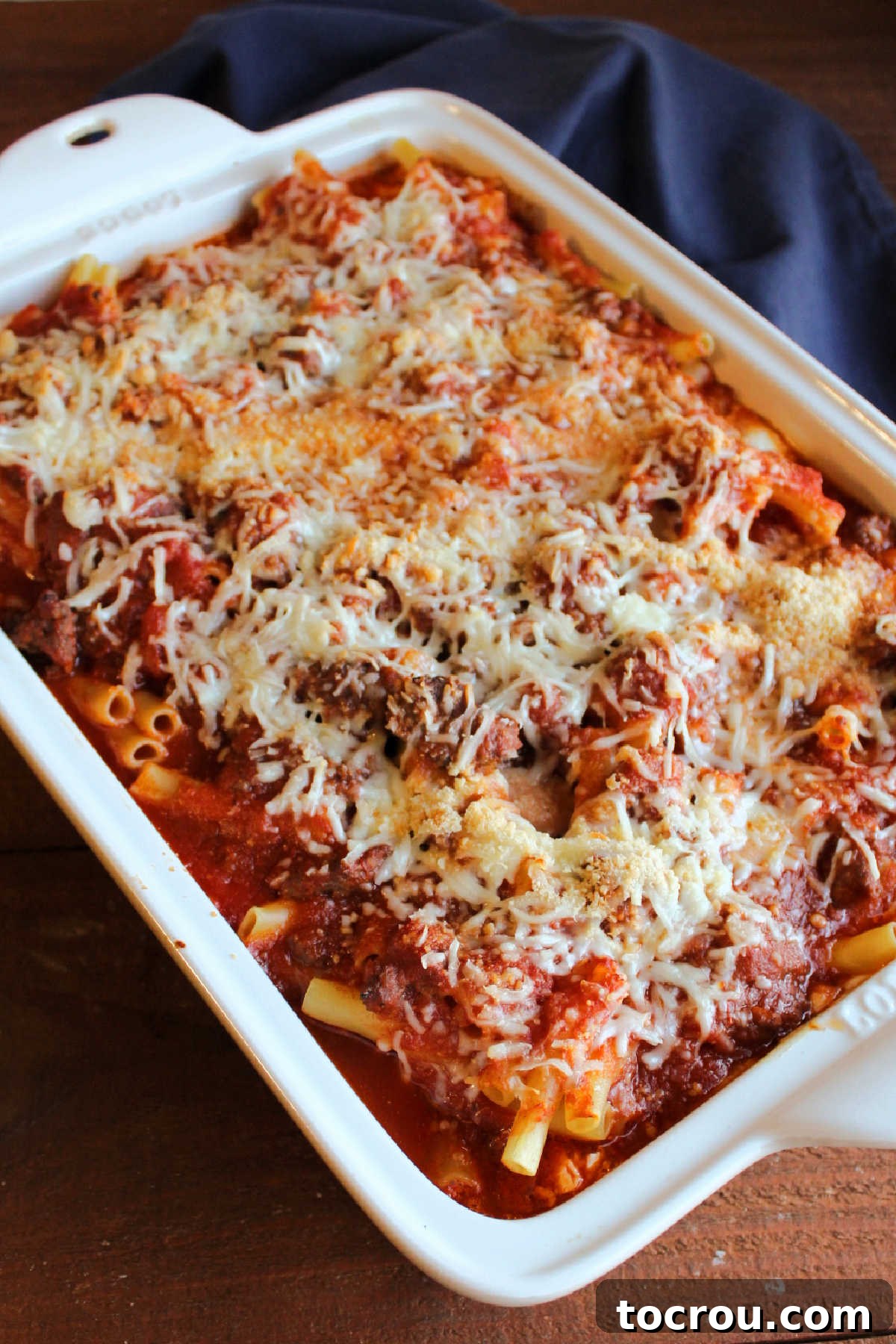 Pan of creamy baked ziti casserole fresh from the oven, featuring a luscious layer of browned, melted cheese on top.