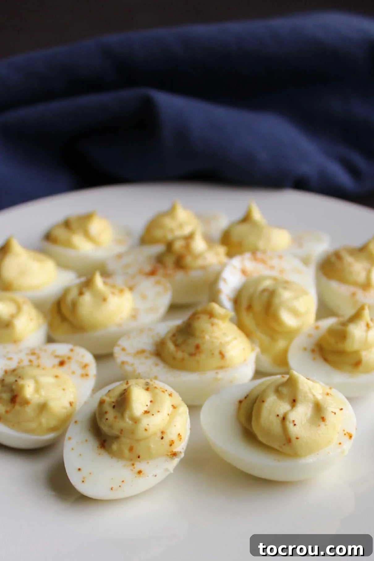 A beautifully arranged plate of deviled quail eggs, garnished with a sprinkle of paprika, ready to be served.