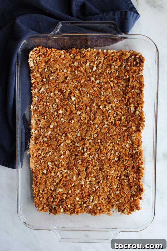 Prepared Pretzel Crust The crispy pretzel crust, pressed firmly into the bottom of a 9x13 inch baking pan, waiting for the creamy filling to be spread over it.