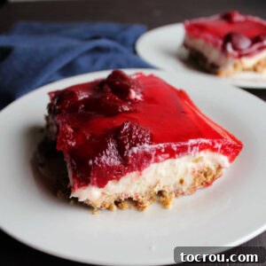 Slices of Strawberry Jello Pretzel Salad, perfectly layered and ready to eat, served on a light background.