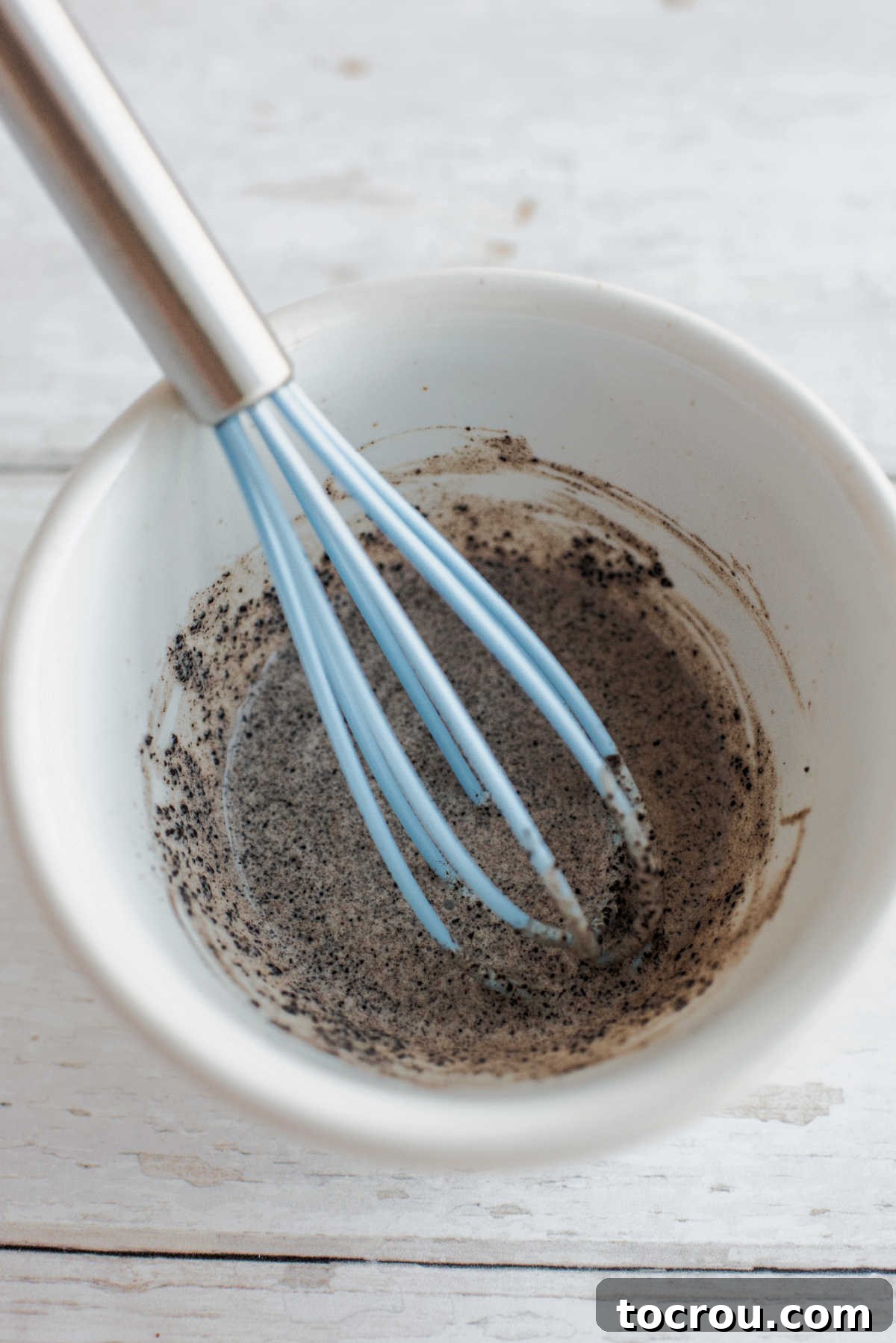 Whisking instant coffee granules into a little bit of cream.