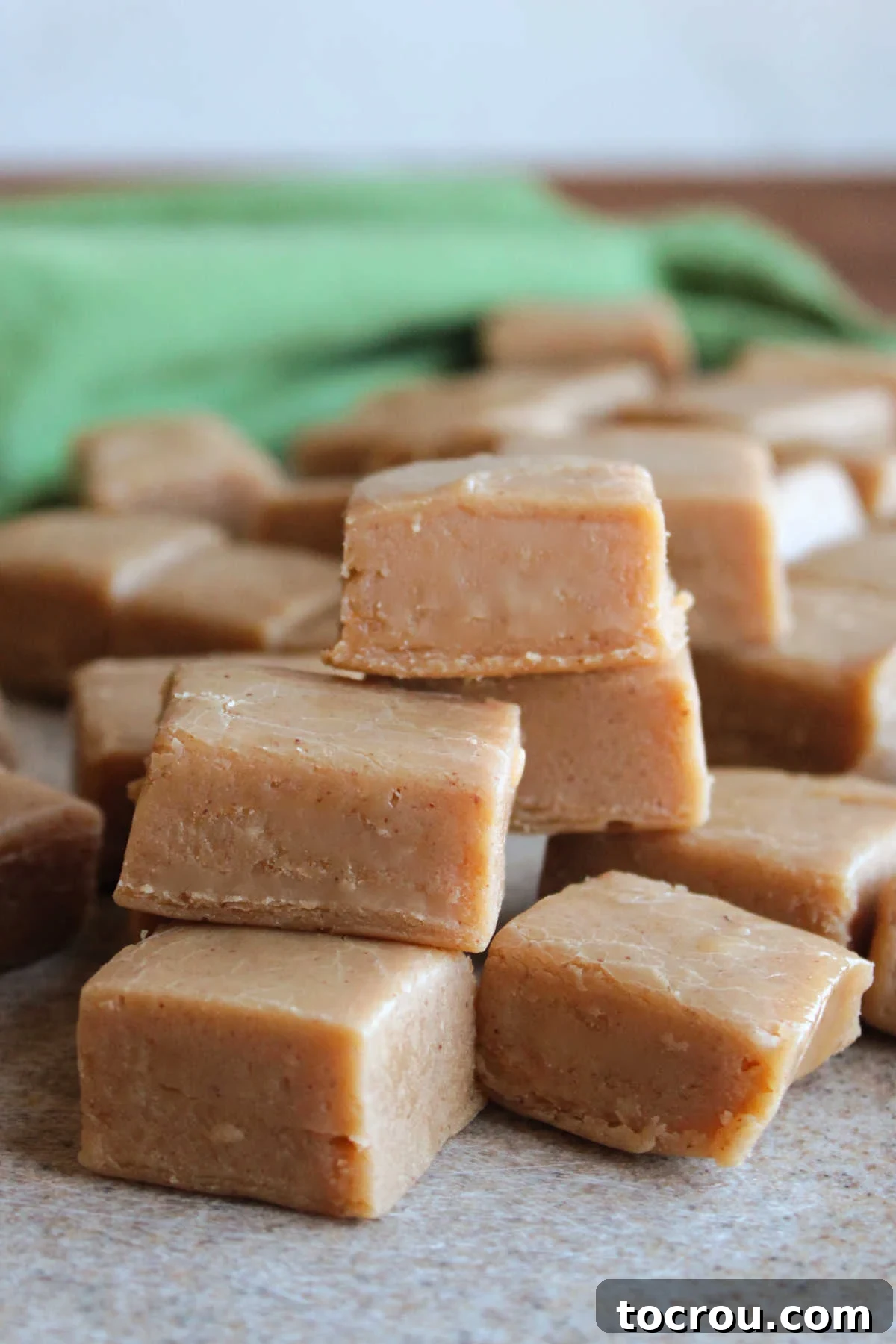 Homemade Fudge Squares on Cutting Board Squares of creamy homemade peanut butter fudge arranged neatly on a cutting board, highlighting their smooth texture and even color.