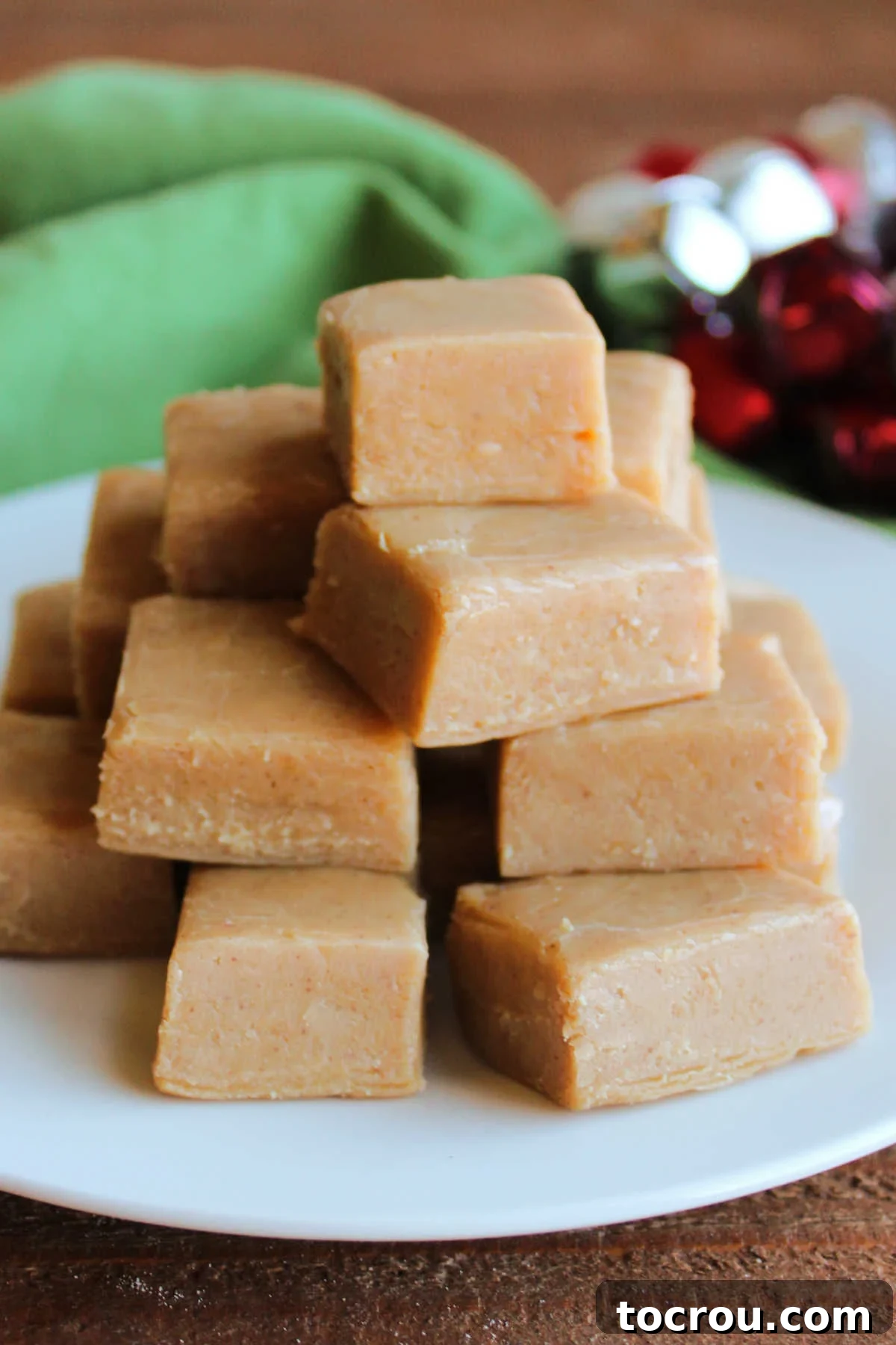 Peanut Butter Fudge Ready to Serve Plate of pieces of homemade peanut butter fudge, neatly stacked and ready to eat. The fudge looks soft and inviting.