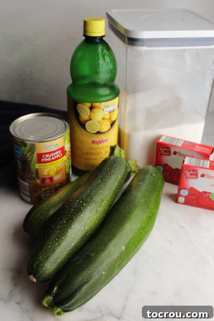 Key Ingredients for Zucchini Jam A display of ingredients for zucchini jam, including granulated sugar, a can of crushed pineapple, lemon juice, and a box of strawberry Jello mix.