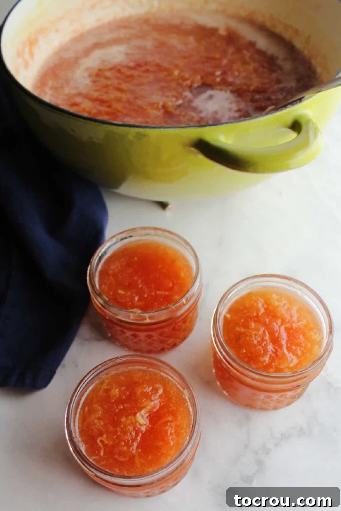 Filling Jars with Freshly Made Jam Hot zucchini jam being spooned into small glass jars, showcasing its vibrant color and smooth texture.