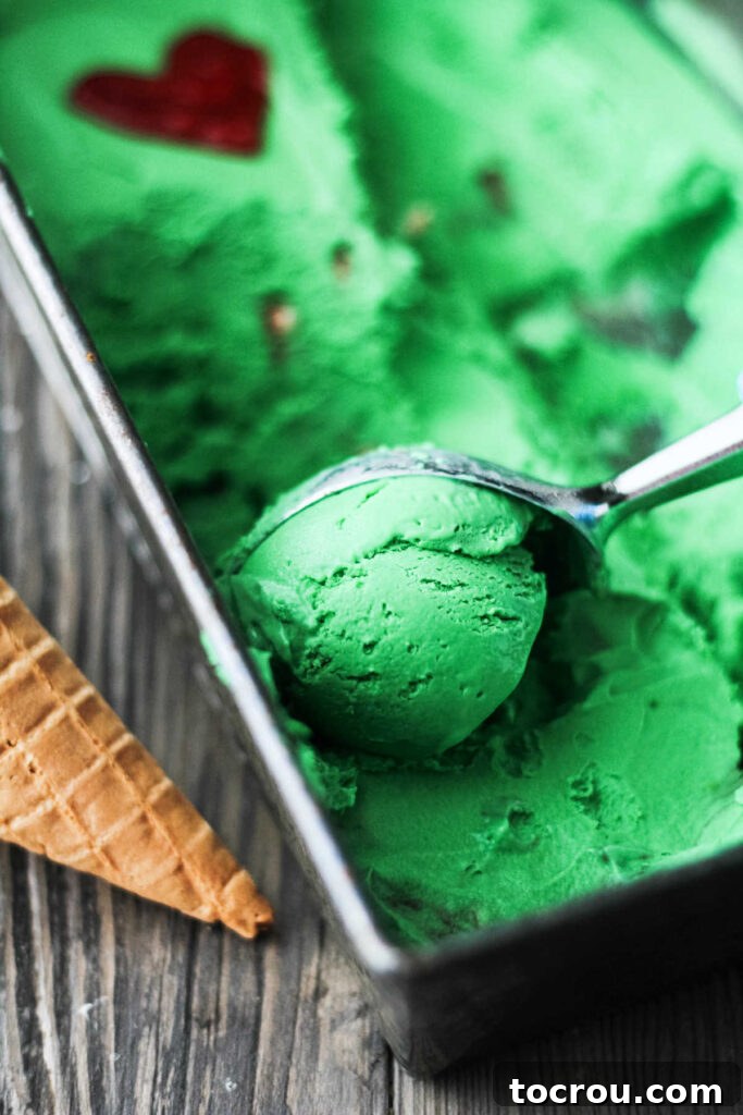 Scooping Grinch Ice Cream getting scoop of green ice cream out of loaf pan.