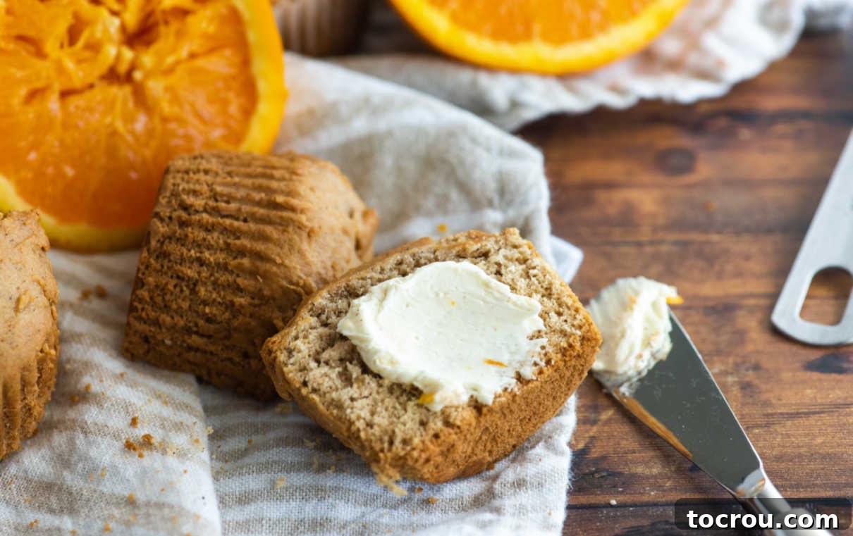 Spreading creamy orange honey butter over a warm orange spice muffin half.