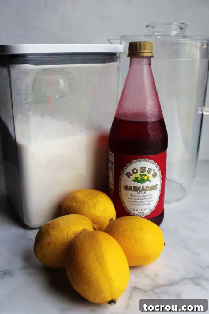 Ingredients for making homemade pink lemonade, including fresh lemons, granulated sugar, and grenadine bottle.
