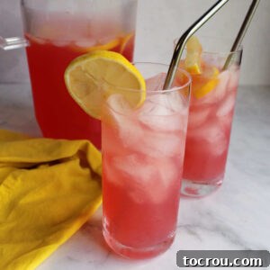 Close-up of glasses of pink lemonade with ice and lemon slices, ready to be served.