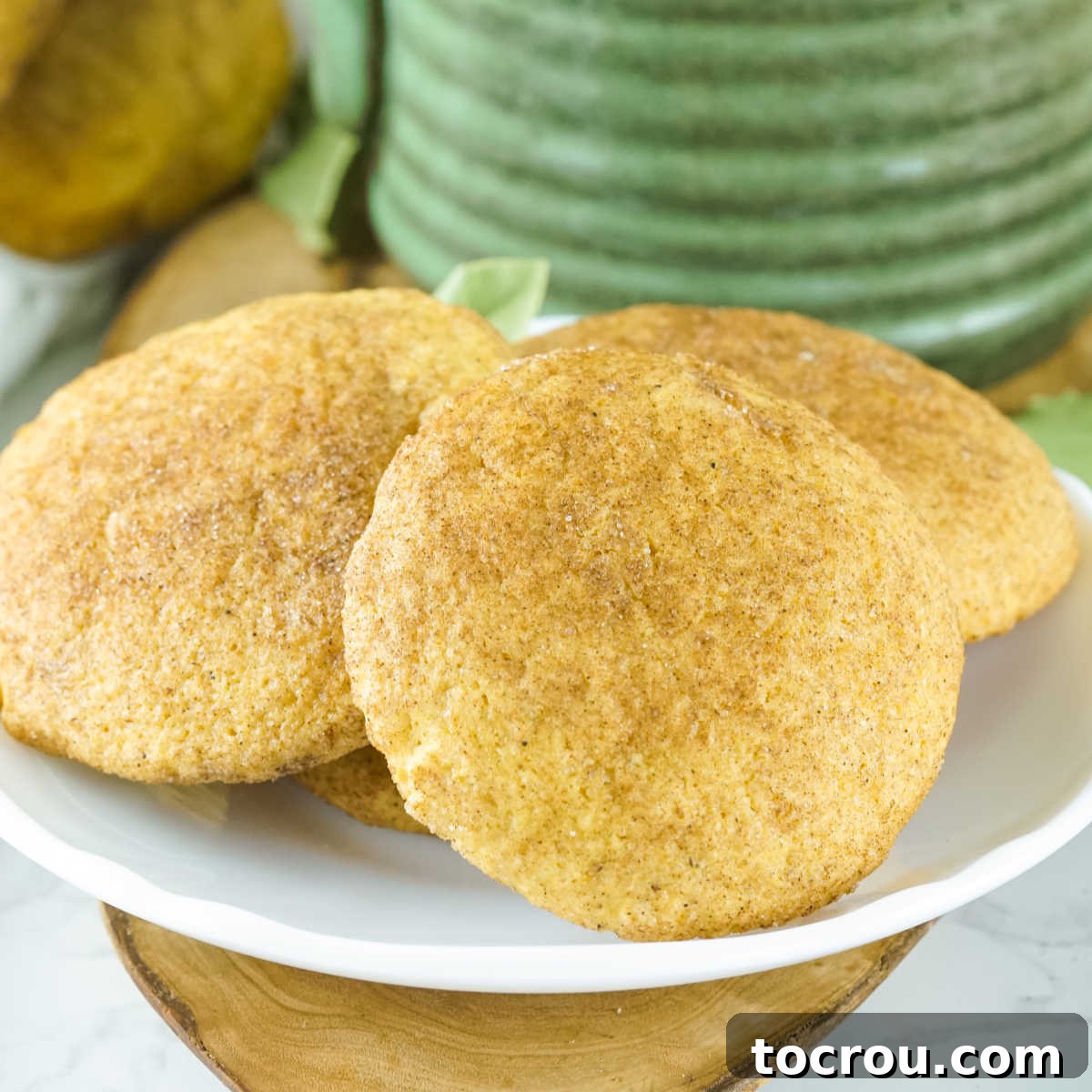 Autumn Pumpkin Snickerdoodles 2 A plate of golden-brown pumpkin snickerdoodle cookies, generously coated in pumpkin spice and sugar, radiating warmth and inviting autumn flavors.