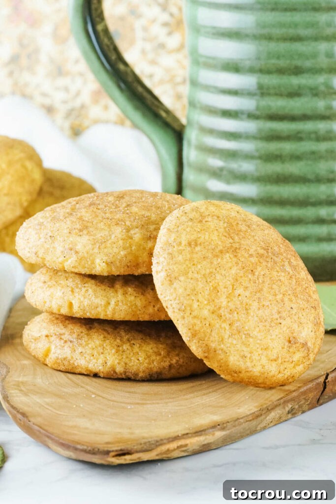 Autumn Pumpkin Snickerdoodles 6 A tempting stack of warm pumpkin snickerdoodle cookies, generously coated in cinnamon sugar, ready to be enjoyed.