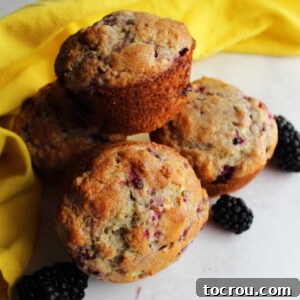 Close stack of golden blackberry muffins ready to eat.