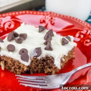 Piece of chocolate chip cookie dough Texas sheet cake with bite missing on red plate with fork.