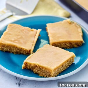 Plate with three pieces of peanut butter sheet cake with peanut butter icing.