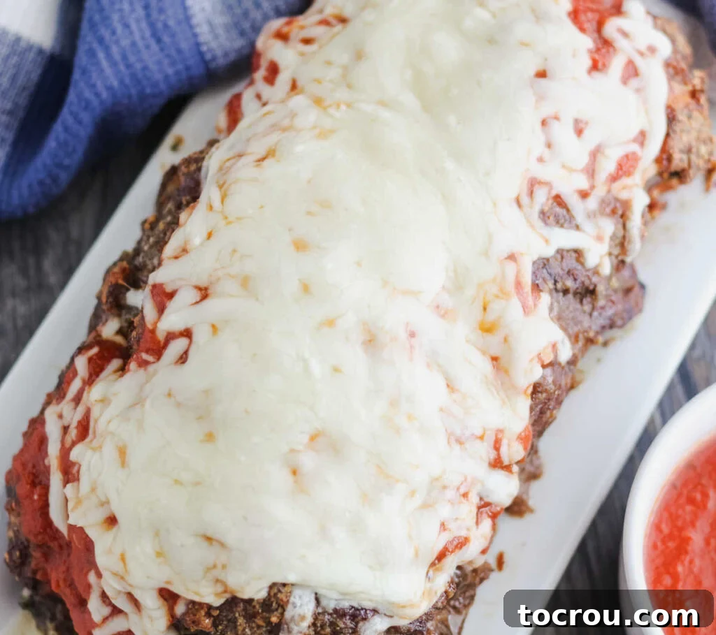 whole meatloaf topped with marinara sauce and melted cheese.