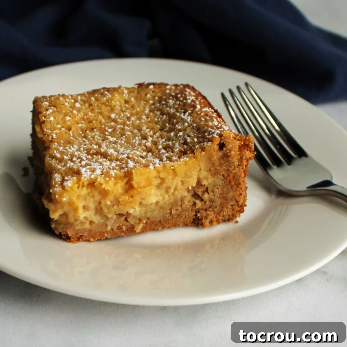 Apple Gooey Butter Cake Slice A generous slice of apple spice gooey butter cake, showcasing its golden cakey crust and incredibly creamy, rich apple butter filling.