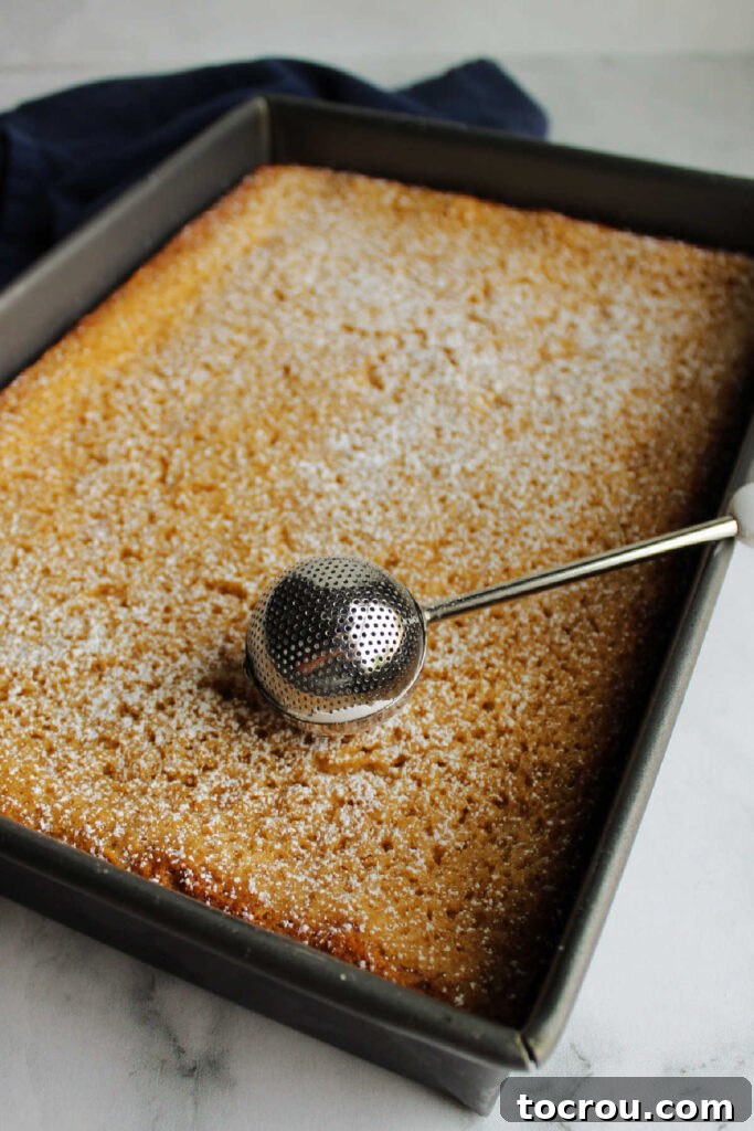 Powdered Sugar Dusting The finished apple gooey butter cake, lightly dusted with a fine layer of powdered sugar, adding a touch of elegance.