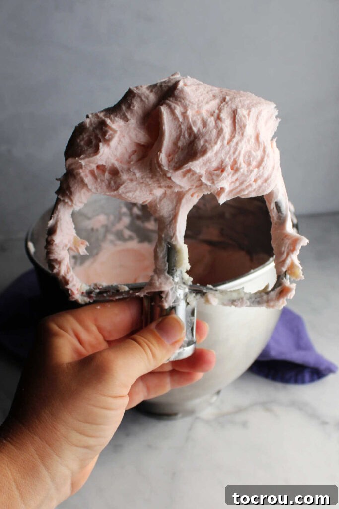 Mixer paddle coated with fluffy, pale pink lemonade frosting.
