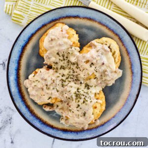 Plate with homemade biscuits and creamy sausage gravy, ready to eat.