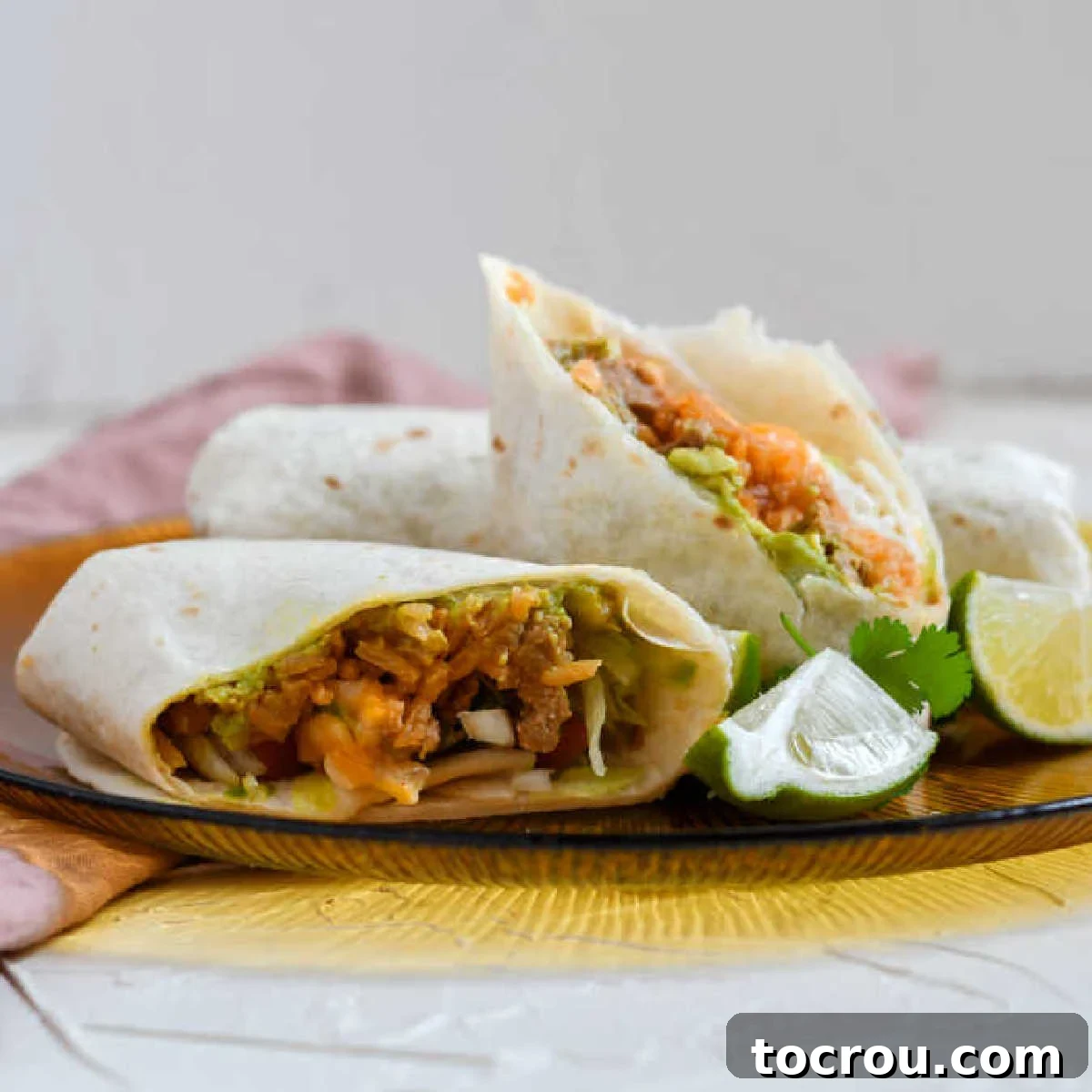 close up of burrito cut in half showing layers of filling inside.