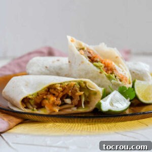 close up of burrito cut in half showing layers of filling inside.