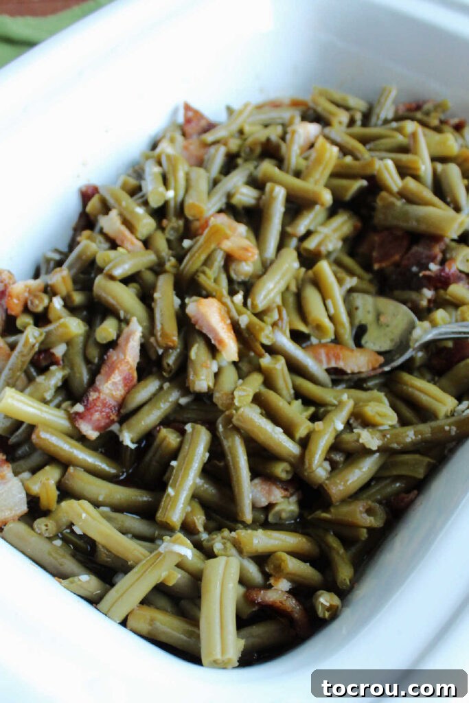 Homestyle Slow Cooker Smothered Green Beans 4 Slow cooker filled with sweet and sour green beans and bacon ready to serve.