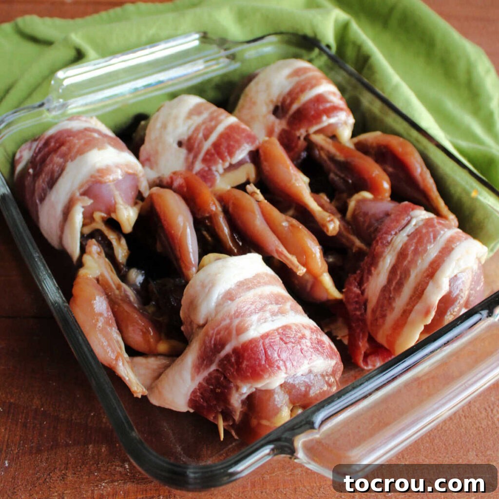 Golden Roasted Bacon Wrapped Quail 6 Marinated quail wrapped in bacon and in pan ready to go in oven.