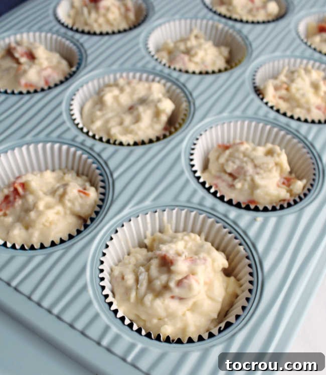 Muffin batter ready for baking Pepperoni pizza muffin batter expertly poured into a greased muffin tin, patiently waiting to be baked to golden perfection.