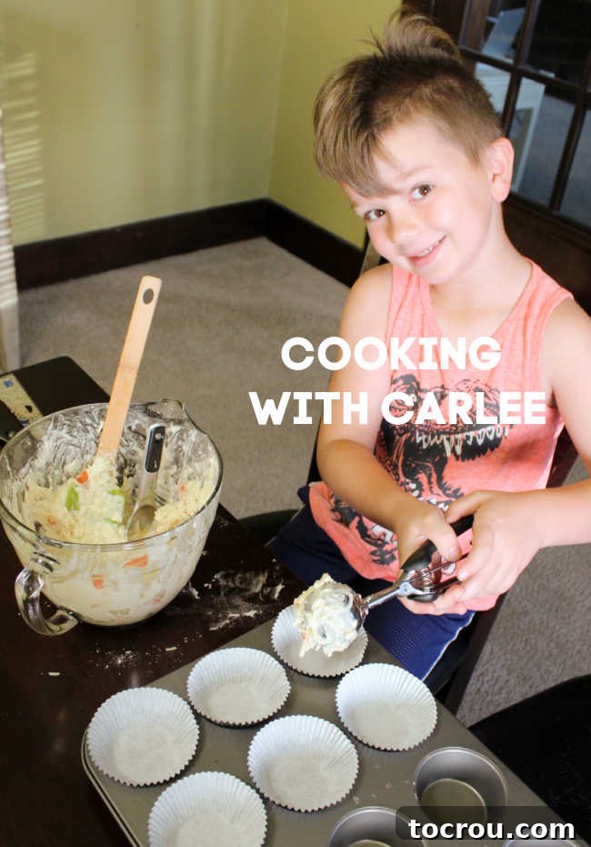 Scooping batter into muffin pan A person efficiently scooping pepperoni pizza muffin batter into a muffin pan, utilizing a large cookie scoop for precision and ease.