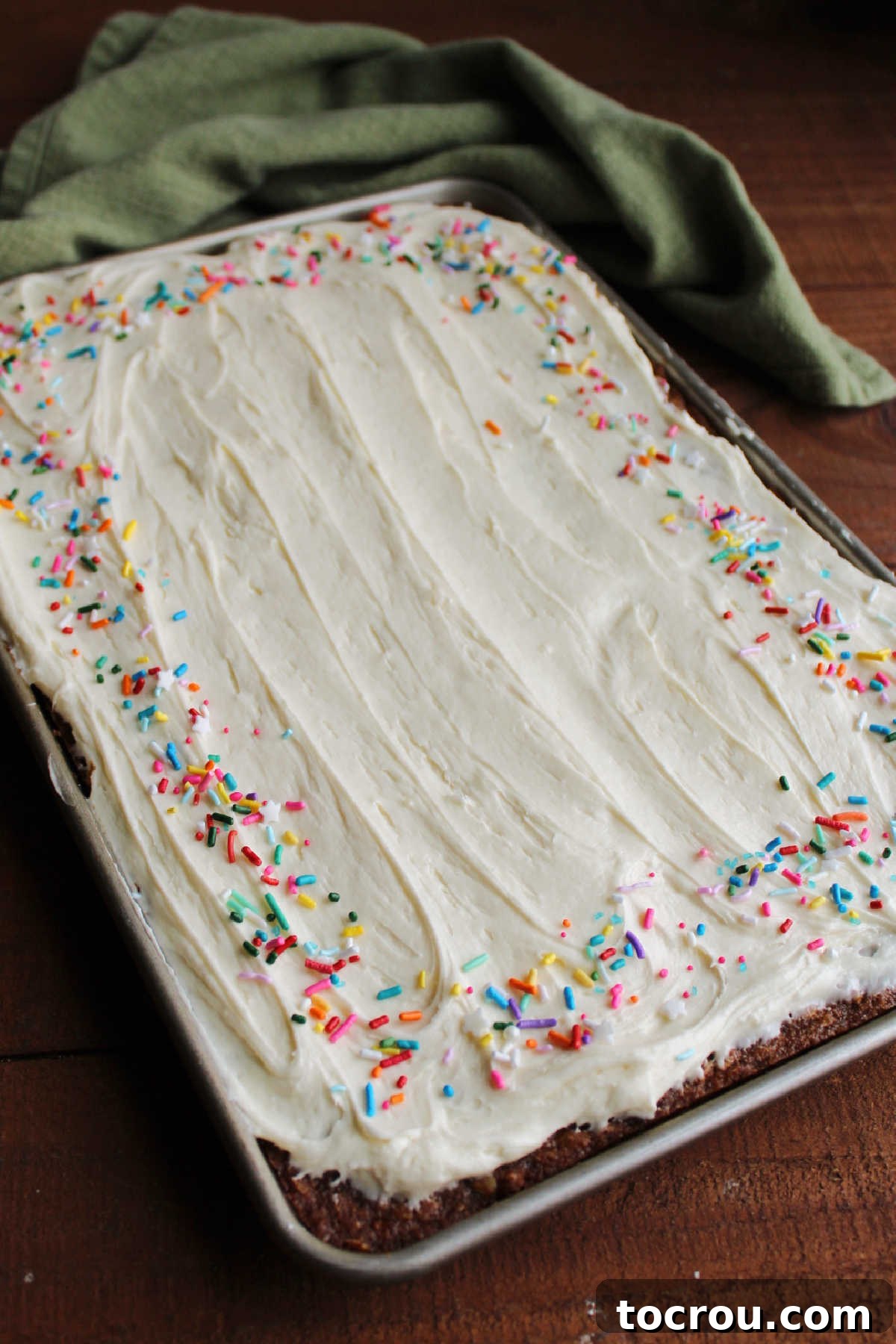 Pan of frosted oatmeal cream pie bars with sprinkles around the edge. 