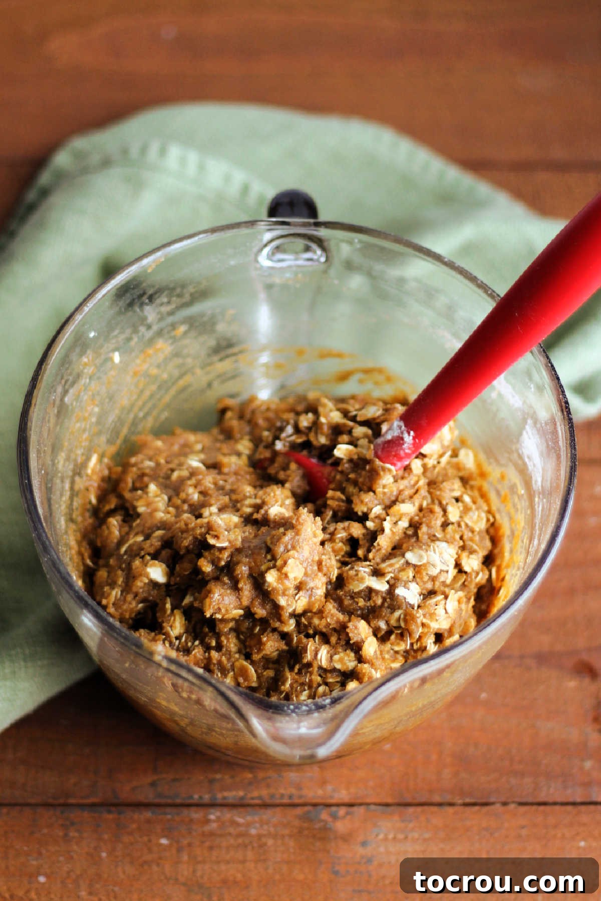 Mixing bowl and spatula with oatmeal cream pie bar dough showing a thick oatmeal and molasses dough that is easy enough to stir together by hand.