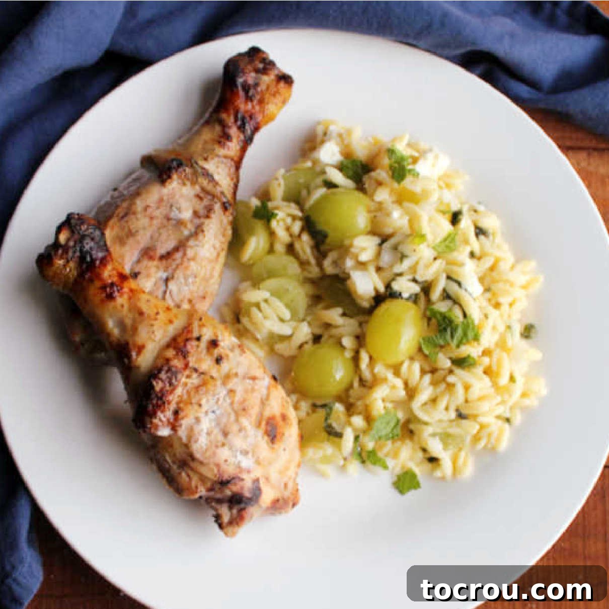 Juicy Lemon Yogurt Marinated Grilled Chicken with Orzo Salad Plated grilled chicken drumsticks marinated in lemon, yogurt, and herbs, served with a vibrant orzo pasta salad.
