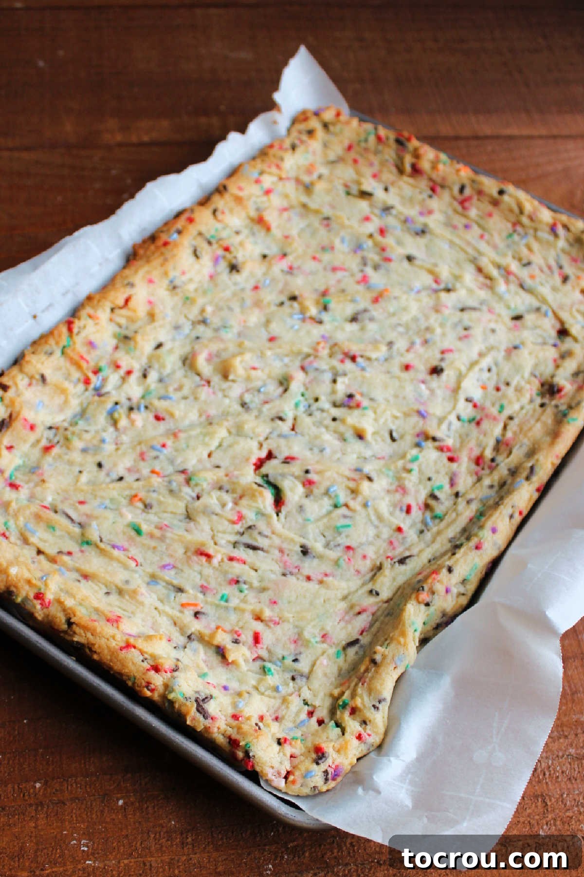 Party Sugar Cookie Bars 5 Freshly baked sprinkle filled sugar cookie bars, showing lightly golden edges and a soft, inviting texture.