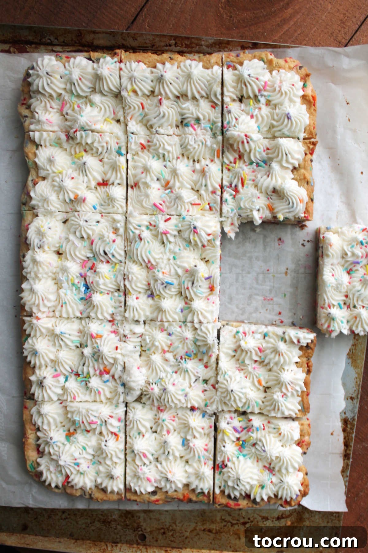 Party Sugar Cookie Bars 6 A perfectly baked, soft sugar cookie bar, cut from a large batch and revealing colorful sprinkles within.