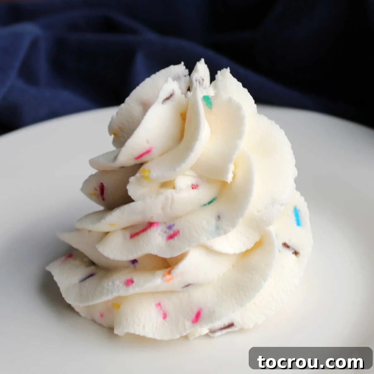 Swirl of buttercream frosting with colorful sprinkles throughout.