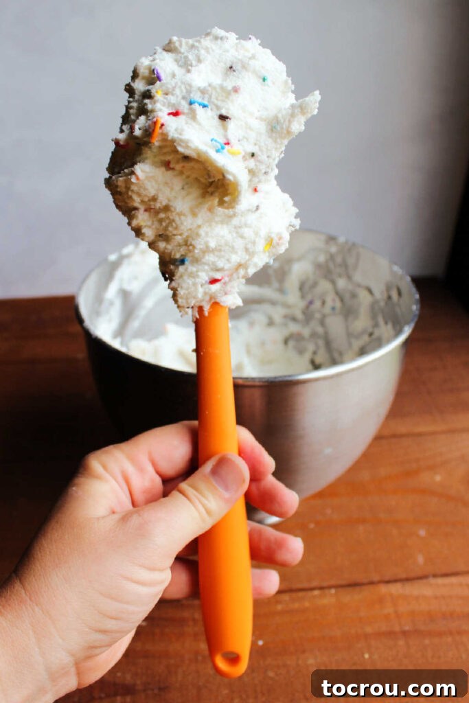 Spatula filled with colorful sprinkle funfetti frosting.