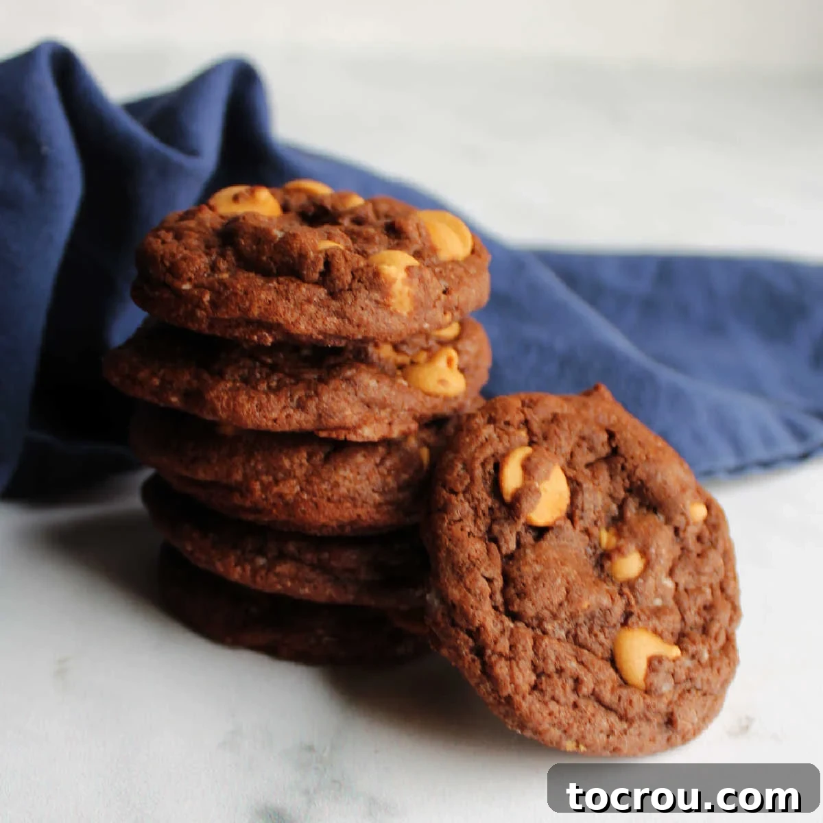 Stack of luscious chocolate cookies studded with golden peanut butter chips, ready to be devoured.