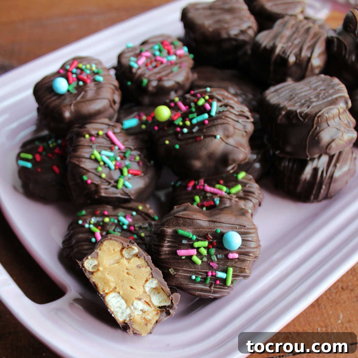 Decadent Chocolate Peanut Butter Pretzel Treats 2 Pink platter piled high with freshly made chocolate peanut butter pretzel bites, showcasing their enticing appearance for a sweet and salty treat.