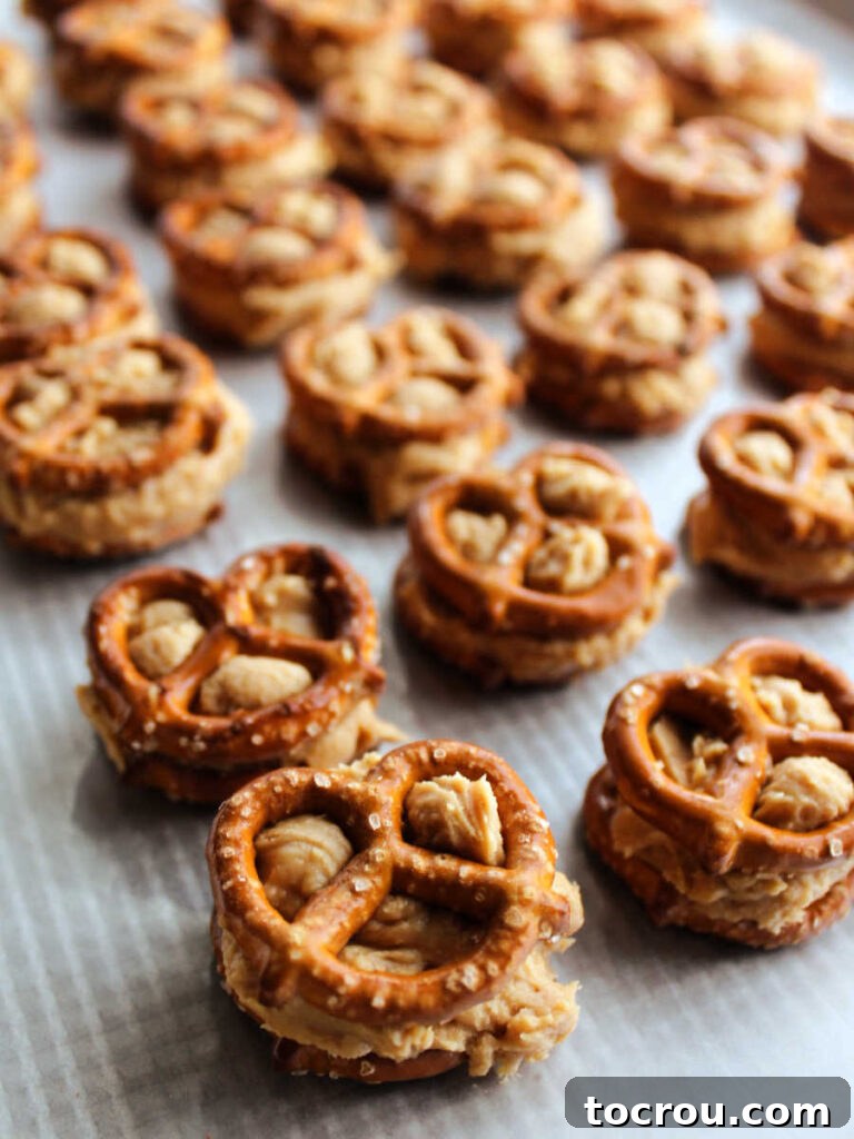 Decadent Chocolate Peanut Butter Pretzel Treats 7 Mini pretzel twists with creamy peanut butter filling sandwiched precisely between them, ready for the next step in making the bites.