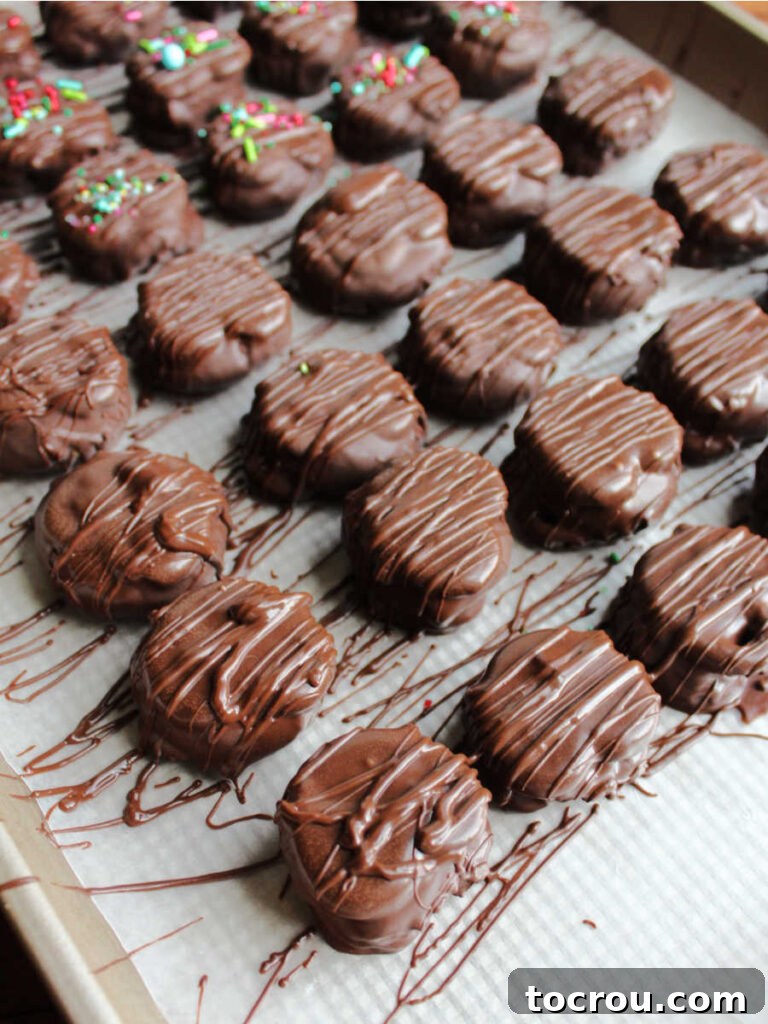 Decadent Chocolate Peanut Butter Pretzel Treats 8 Freshly chocolate-dipped peanut butter pretzel bites arranged neatly on wax paper, allowing the chocolate shell to harden and set perfectly.