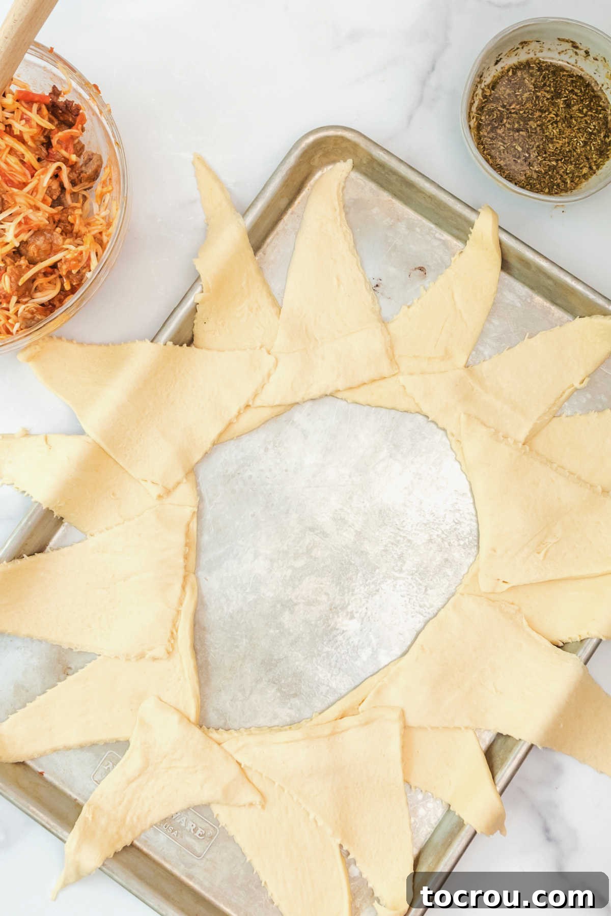 Second layer of crescent dough triangles placed over first layer, offset slightly to make wreath.