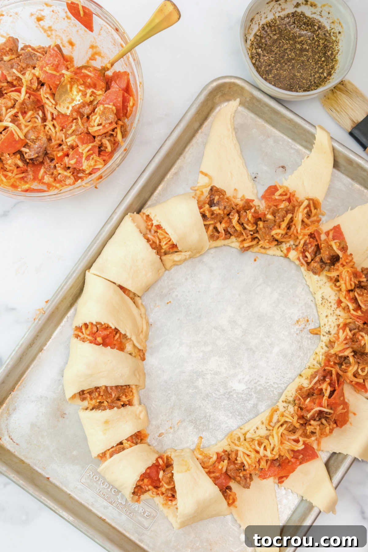 Half of the crescent dough folded over pizza filling with the other half waiting to be folded over.
