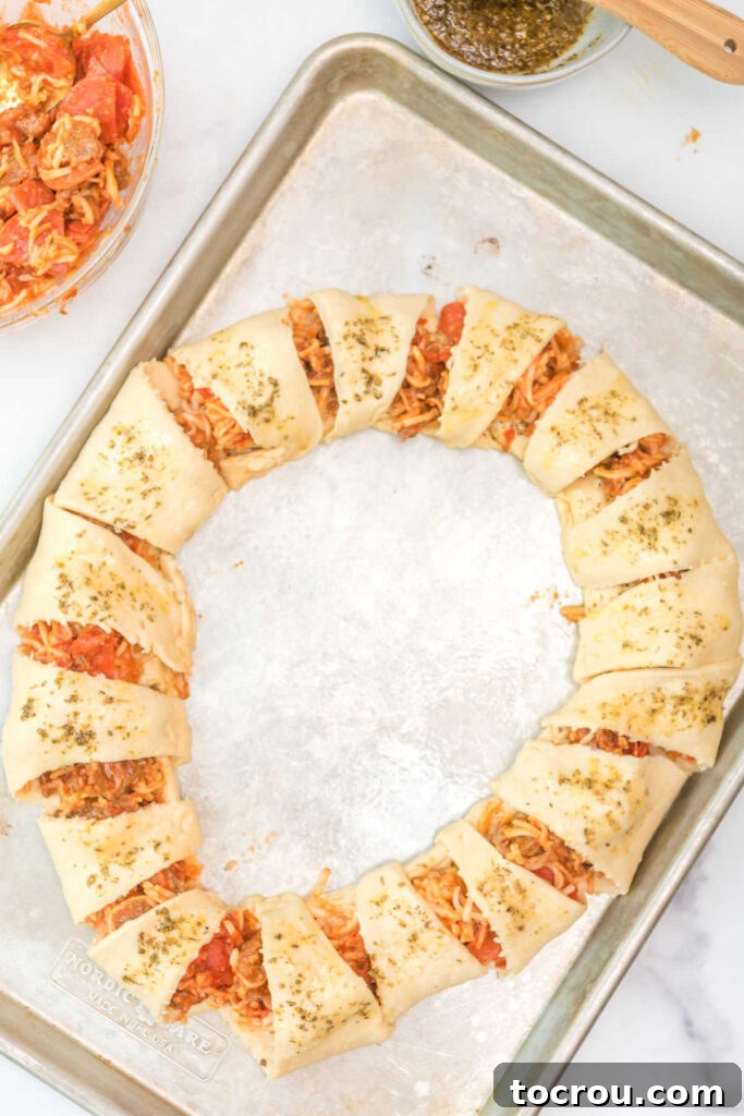 Assembled pizza crescent ring brushed with seasoned olive oil ready to bake.