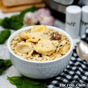 Bowl of creamy soup with tortellini, sausage and spinach ready to eat.